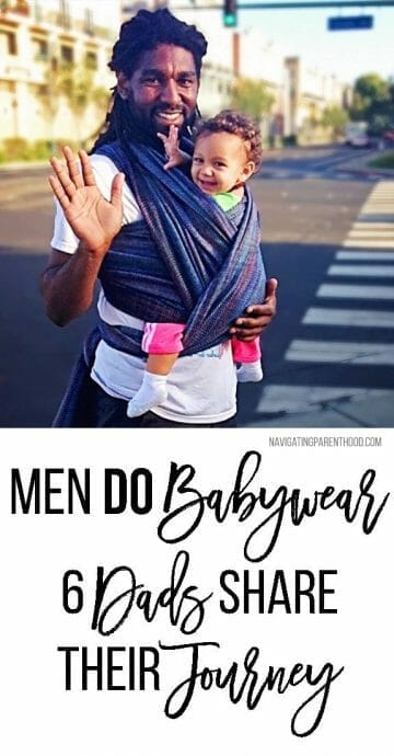 black dad waves at camera while walking in crosswalk and babywearing in a wrap with baby daughter