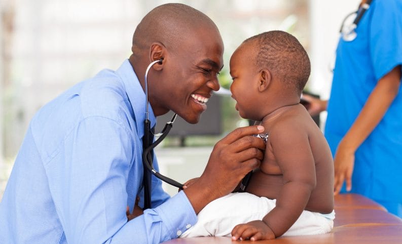 happy doctor examining baby boy