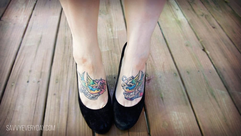 Close up of woman's feet (in heels), with tatoos on the tops of her feet.