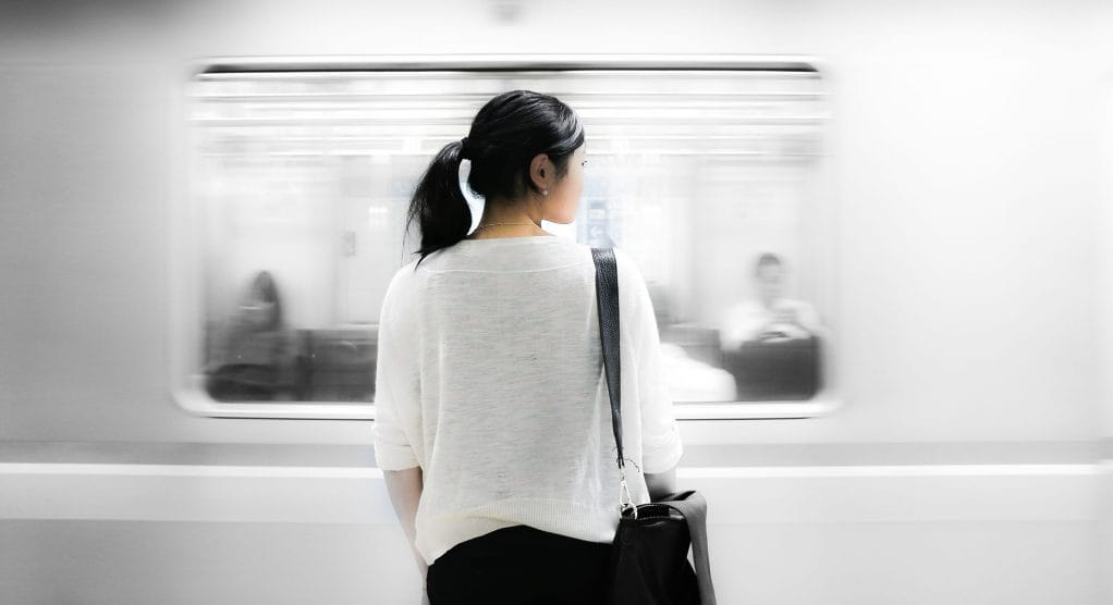 Woman standing in front of fast moving train