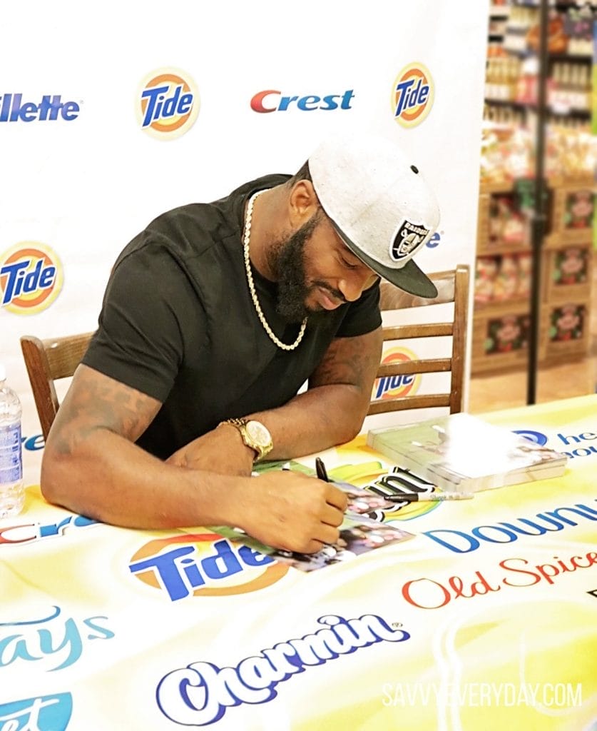 Marcel smiles while signing