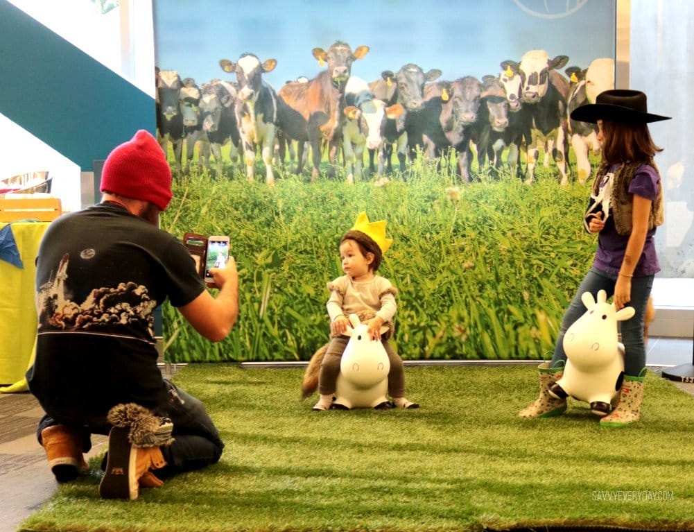 dad taking pics of kids in front of photo backdrop at MommyCon