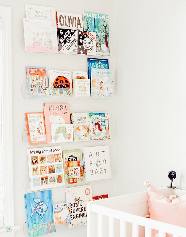 Beautiful clear bookshelf full of tot books in Wonderland nursery