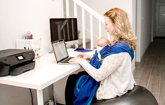 sitting on birthing ball at desk, researching things while babywearing