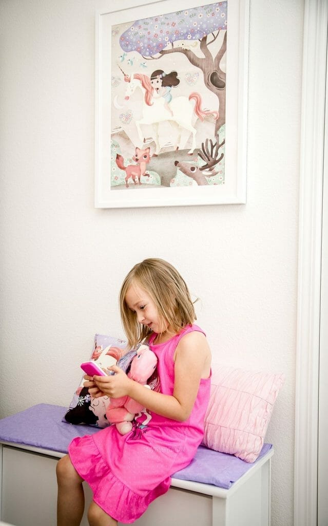 S sitting on her unicorn room bench