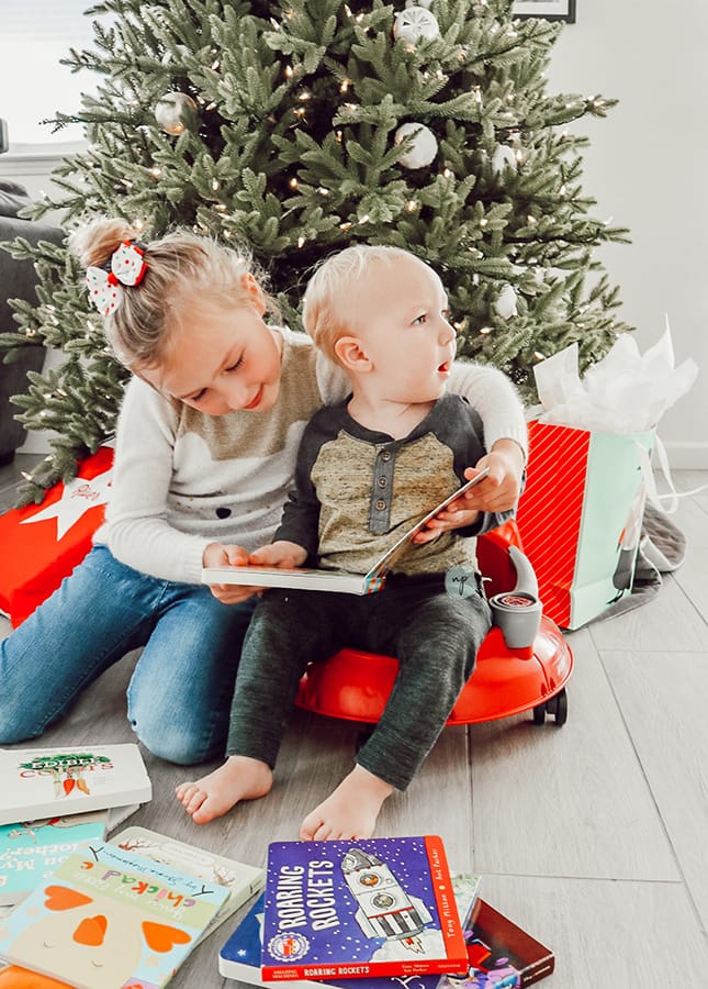 River and S reading a book by the Christmas tree