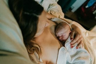 baby laying on mother's chest during golden hour - hospital bag checklist