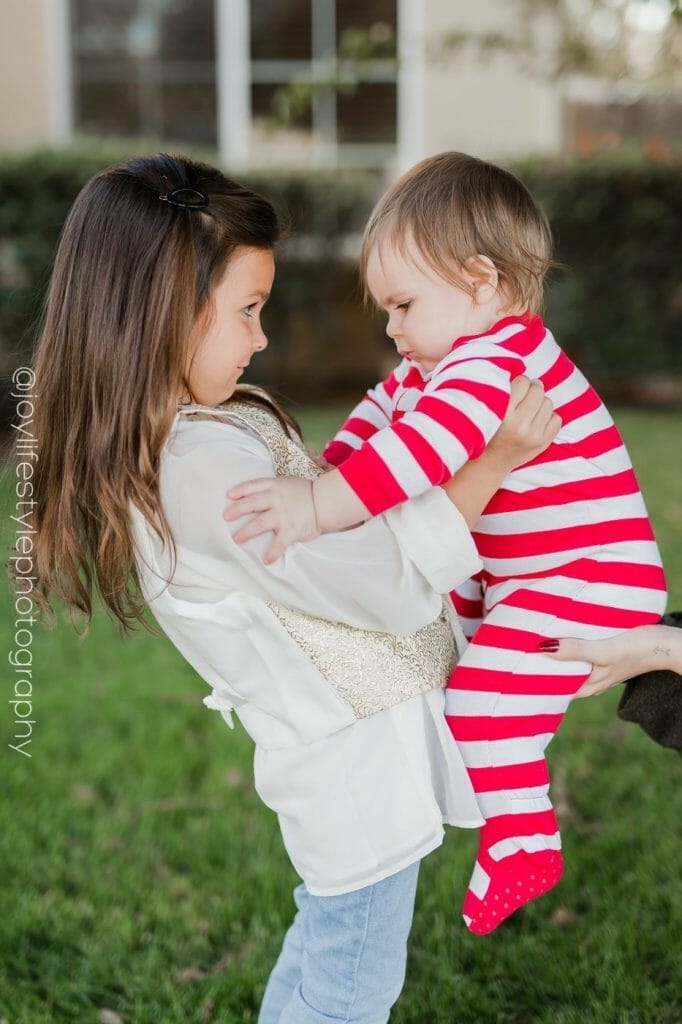 Big sister holding baby brother