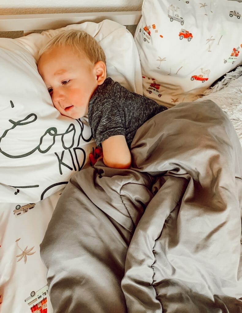 toddler sleeping in his own big kid bed