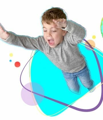 Boy jumping through a white background with colorful shapes