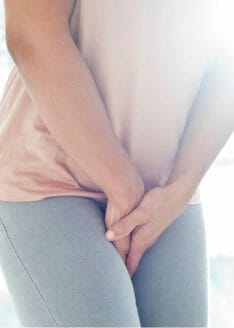 woman with pelvic pain holding between her legs