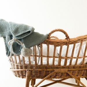 wicker bassinet with teal blanket