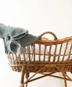 wicker bassinet with teal blanket