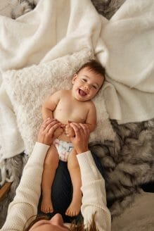 Happy baby laughs during infant massage