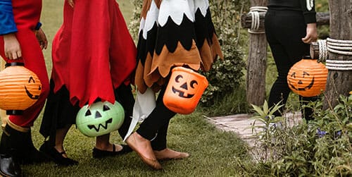 kids in costumes with trick or treat buckets