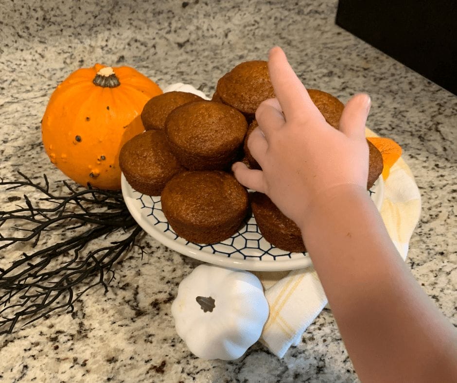 kid grabbing a pumpkin cupcake