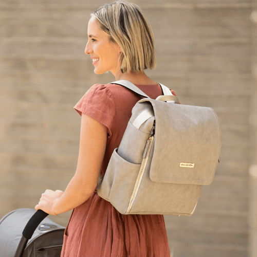 Mom pushes stroller with diaper bag backpack