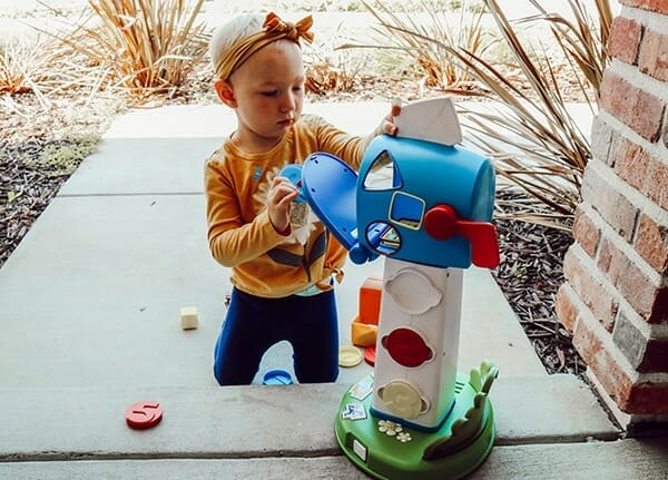 toddler plays with little tikes mailbox