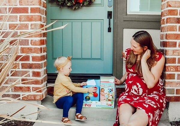 toddler and mom sit on front door steps