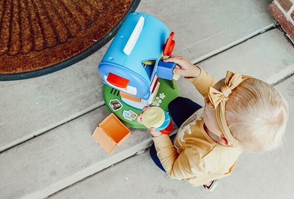 toddler opens learning post office box while practicing post office learning activities