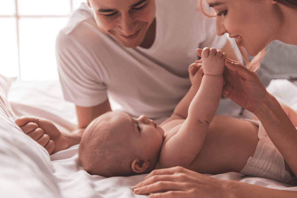 mom and dad smile down at newborn