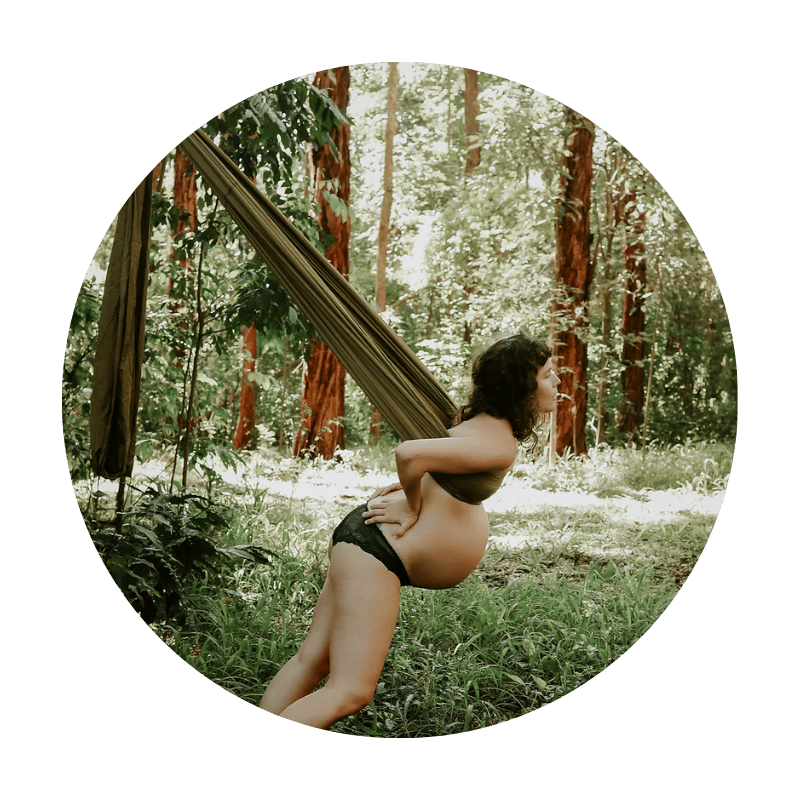 Pregnant woman in woods using The Birth Sling