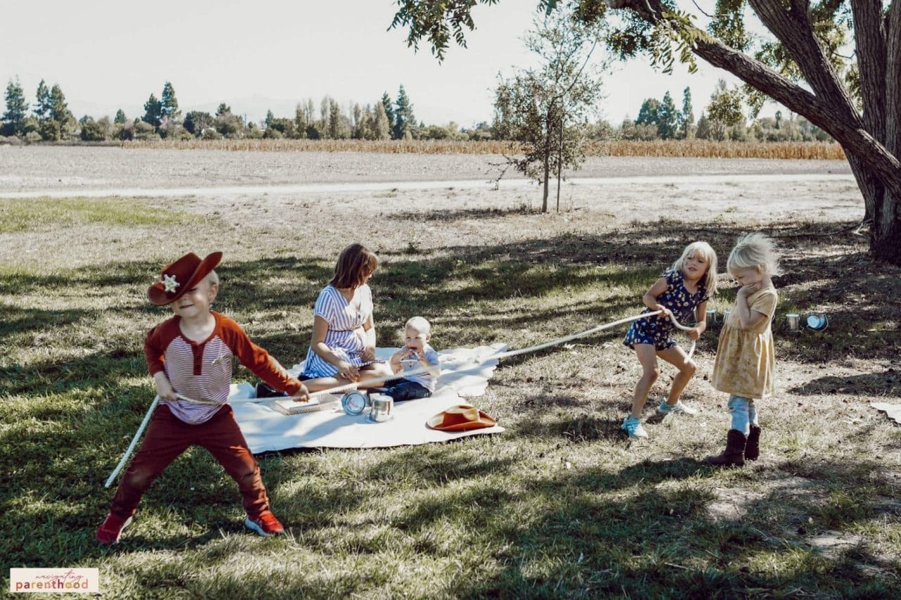 kids playing tug-of-war at a Wild West first birthday party