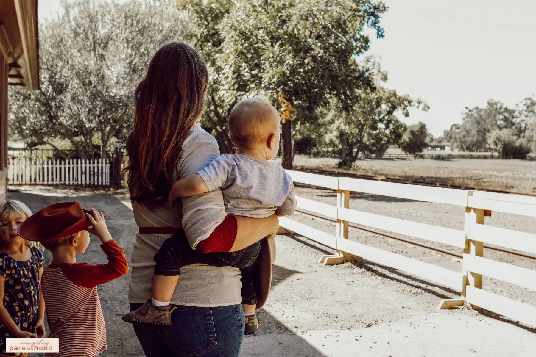 Mom and kids wait for a train to arrive