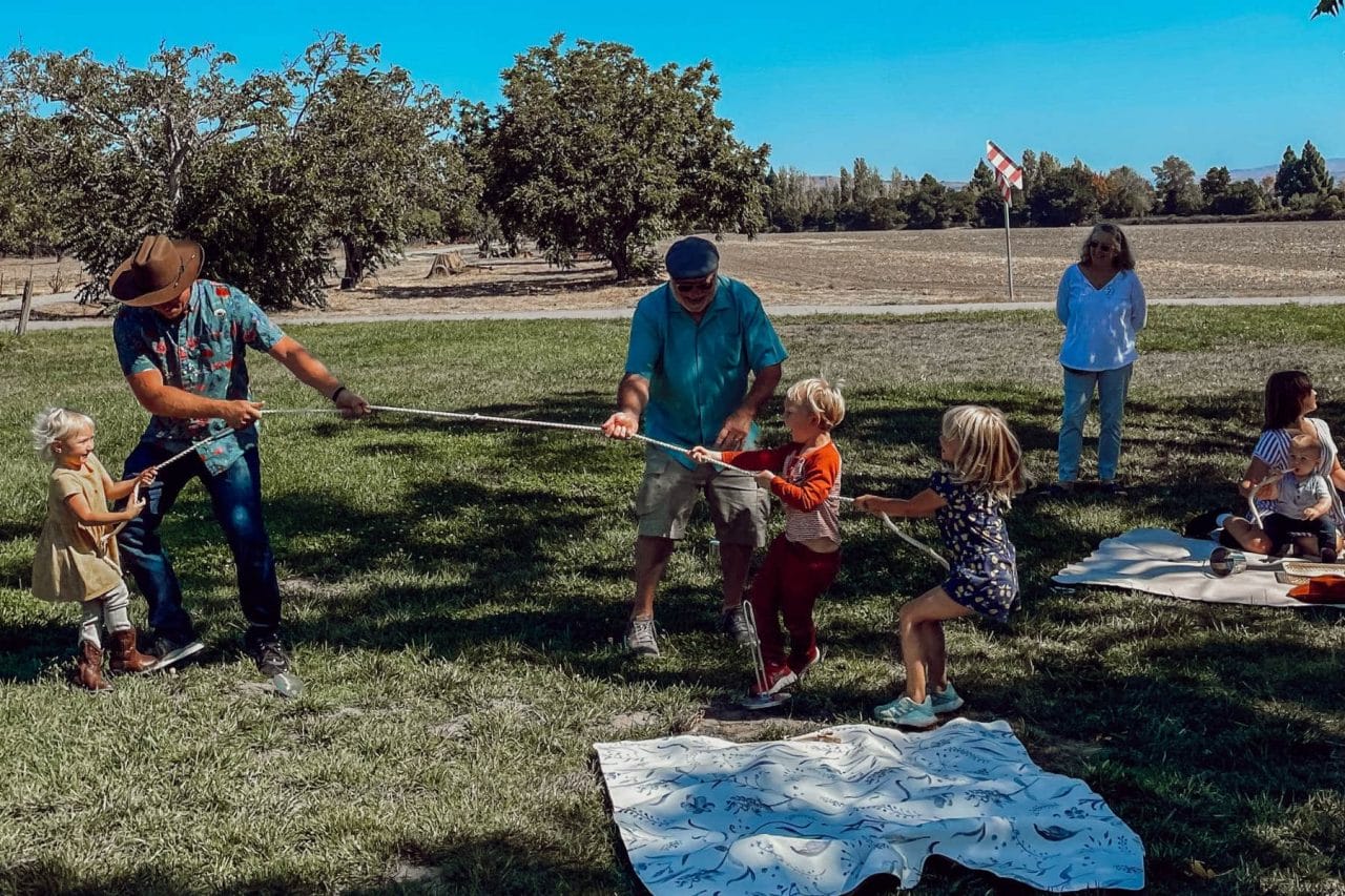 adults and kids play tug-of-war at a Wild West first birthday party