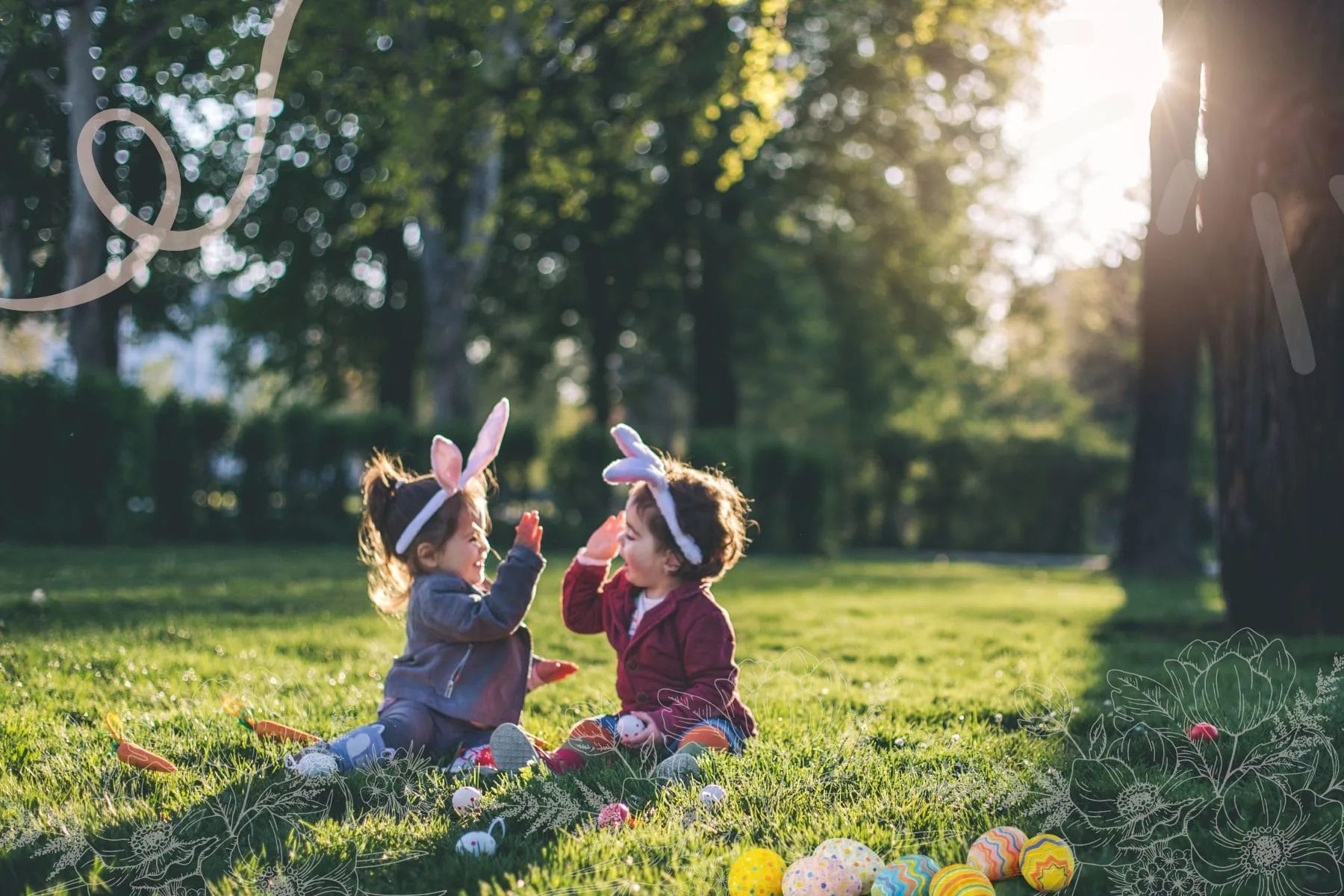 Two toddlers sitting on a grassy field with Easter eggs